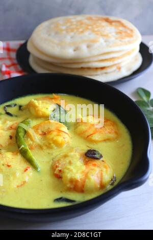 Crevettes jaunes ou curry de crevettes servies avec Amboli ou Soft Dosa. Crevettes cuites dans du lait de coco aux épices douces. Curry thaïlandais jaune de crevettes. Curry de Goan. Banque D'Images