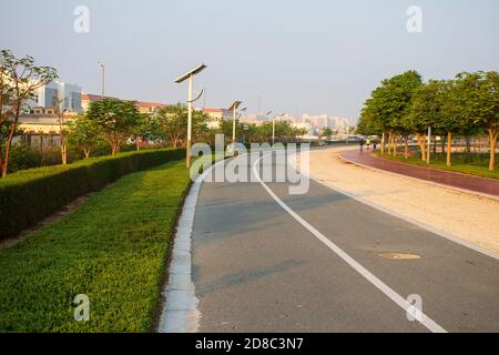 Pistes de jogging et de vélo dans le parc Al Warqa, Dubaï, Émirats arabes Unis tôt le matin. Le poteau de lampe alimenté par des panneaux solaires peut être vu dans l'image. À l'extérieur Banque D'Images
