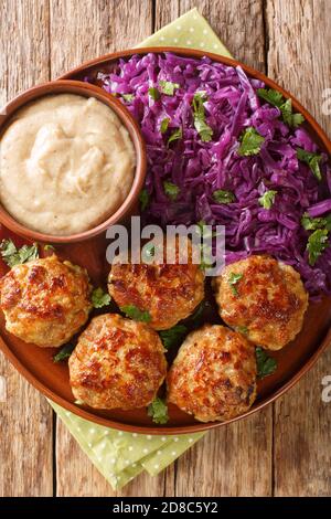 Boulettes de viande danoises frikadeller servi avec une garniture de chou rouge ratée dans une assiette sur la table. Vue verticale du dessus Banque D'Images