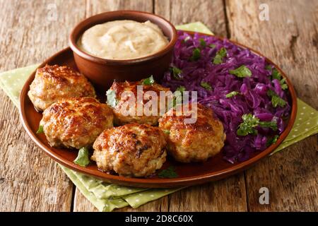 Délicieux boulettes de viande frites avec chou rouge chaud et sauce en gros plan dans une assiette sur la table. Horizontale Banque D'Images