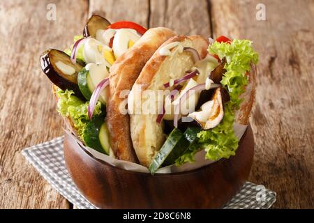 Recette pour un sabotage un sandwich du Moyen-Orient contient de l'aubergine frite, de l'œuf dur, du houmous et d'autres légumes en gros plan sur la table. Horizontale Banque D'Images