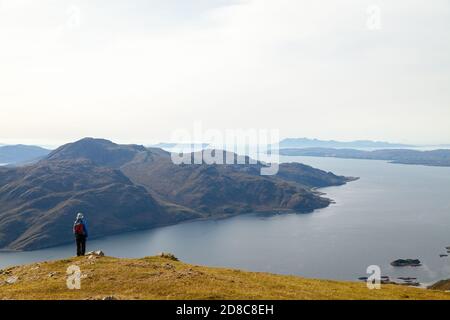 Un marcheur s'arrête pour admirer la vue sur le Loch Hourn Et à la distance de Rum & Eigg de la descente De la Corbett Beinn na h-Eaglaise Banque D'Images