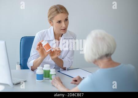 Femme médecin prescrivant des médicaments aux patients âgés Banque D'Images