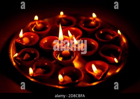 Lampes à huile de diya d'argile allumées ou illuminées pendant la fête de diwali dans un fond sombre à la maison. Concept pour le festival indien hindou diwali, wor ritualiste Banque D'Images