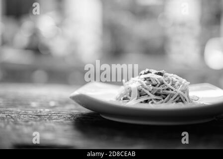 Spaghetti à la sauce pesto contre la table en bois Banque D'Images