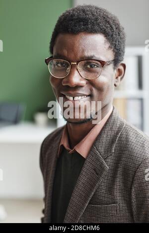 Portrait d'un homme africain réussi en lunettes et en décontracté des vêtements souriants à l'appareil photo Banque D'Images