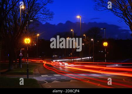 la circulation passant devant le feu à éclats de belisha clignote à l'intersection de zébra au crépuscule leeds Yorkshire royaume-uni Banque D'Images