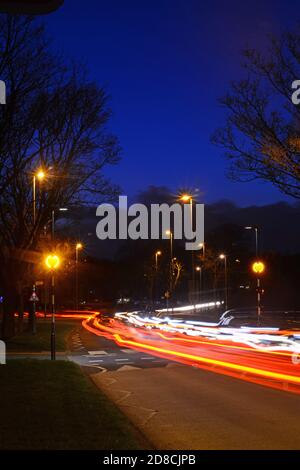 la circulation passant devant le feu à éclats de belisha clignote à l'intersection de zébra au crépuscule leeds Yorkshire royaume-uni Banque D'Images