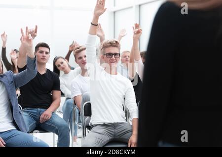 Groupe de jeunes lèvent la main pour poser une question. Banque D'Images