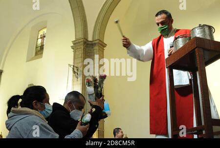 Mexico, Mexique. 28 octobre 2020. MEXICO, MEXIQUE - 28 OCTOBRE : Un fidèle de San Judas Tadeo, prend une image religieuse à bénir dans le temple de San Hipolito, pendant les célébrations de San Judas Tadeo pour remercier le saint d'avoir fait ses faveurs et de pardonner leurs péchés, dans le cadre de la nouvelle pandémie de coronavirus le 28 octobre 2020 à Mexico, Mexique crédit: L'accès photo/Alamy Live News Banque D'Images