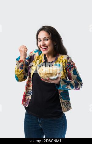 Indienne asiatique jolie jeune fille mangeant des chips de pomme de terre sur blanc arrière-plan Banque D'Images