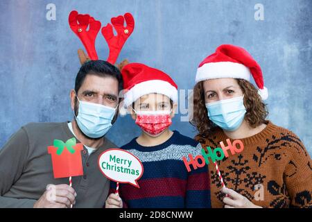 Bonne famille avec des maks pour le visage à Noël Banque D'Images