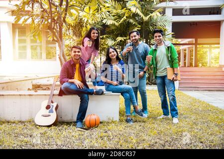 Groupe asiatique indien d'étudiants d'université ayant le thé de café ensemble en pause dans les locaux du campus à l'extérieur. Ayant chat de chit Banque D'Images