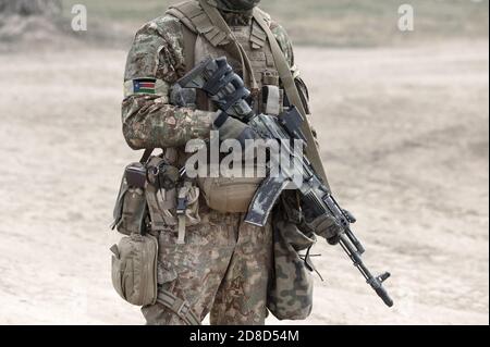 Soldat avec fusil d'assaut et drapeau du Soudan du Sud sur l'uniforme militaire. Collage. Banque D'Images