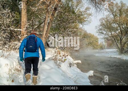 Un homme âgé fait de la randonnée le long de la rivière poudre à fort Collins, Colorado - paysage d'automne brumeux avec une neige fraîche Banque D'Images