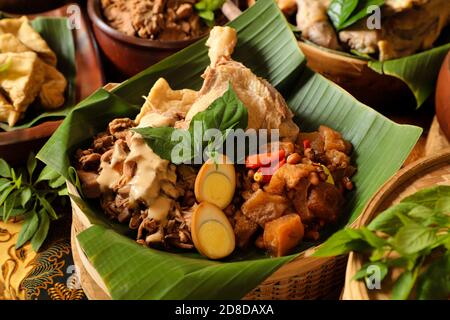 Gudeg Jogja. Le plat javanais se compose de ragoût de fruits de Jack, de curry de poulet et de ragoût épicé de craquelins en peau de bétail dans un panier de bambou Banque D'Images