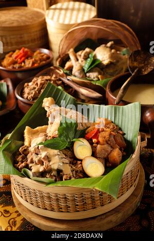 Gudeg Jogja. Le plat javanais se compose de ragoût de fruits de Jack, de curry de poulet et de ragoût épicé de craquelins en peau de bétail dans un panier de bambou Banque D'Images