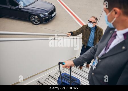 Entrepreneur d'affaires monter les marches de l'avion Banque D'Images