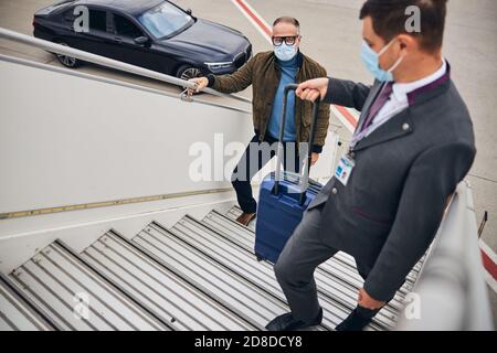 Homme dans des vêtements décontractés à bord de l'avion Banque D'Images