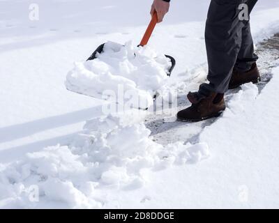 Gros plan sur une photo d'un travailleur qui a fait de la neige sur le trottoir Banque D'Images