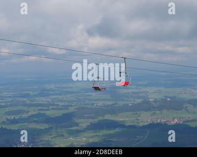 Télésiège dans les alpes bavaroises en période de changement climatique Et Covid-19 avec chaises rouges vides Banque D'Images