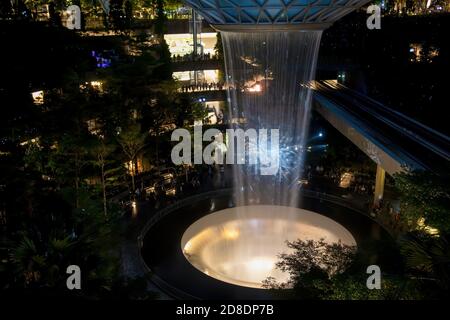 SINGAPOUR - 3 MARS 2020 : chute d'eau au CENTRE commercial JOYAU du terminal 4 de l'aéroport changi singapour dans la soirée. Spectacle de lumière sur l'eau Banque D'Images