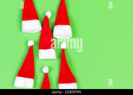 Vue de dessus od rouge élégant Santa hats sur fond coloré. Joyeux Noël concept avec copie espace. Banque D'Images