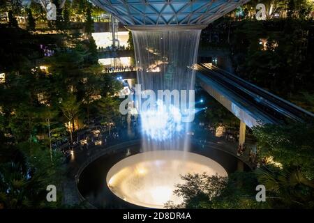 SINGAPOUR - 3 MARS 2020 : chute d'eau au CENTRE commercial JOYAU du terminal 4 de l'aéroport changi singapour dans la soirée. Spectacle de lumière sur l'eau Banque D'Images