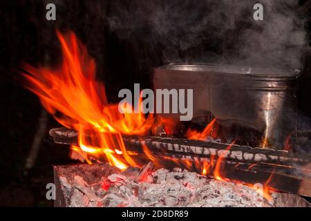 dîner au camping. bouilloire sur un feu de cheminée, feu, fumée. préparation d'un repas lors d'un voyage. repos sauvage. Banque D'Images