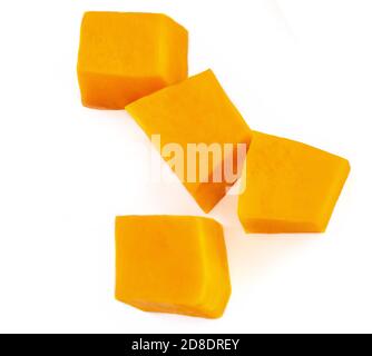 Citrouille coupée en dés sur fond blanc. Morceaux de citrouille frais coupés dans une tranche de cube, vue de dessus. Pose à plat Banque D'Images