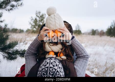 Un jeune couple se berce dans la neige en hiver. Banque D'Images