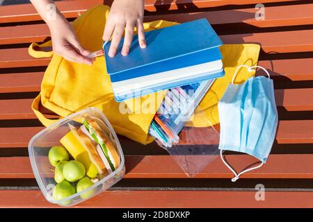 Boîte à lunch, mains des enfants. Sandwichs avec pain, concombre, saucisse, pommes dans un récipient en plastique. Petit-déjeuner scolaire, déjeuner. Retour à l'école. Déjeuner de brea Banque D'Images