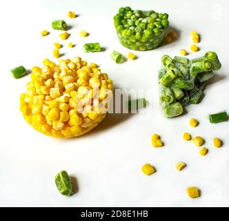 Légumes surgelés gros plan sur un fond blanc maïs congelé, pois verts, haricots verts hachés Copy space vegan food concept écologique durable Banque D'Images