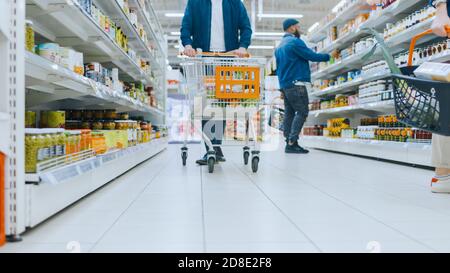 Vidéos à angle bas au supermarché : section des produits en conserve, clients parcourant les étagères et achetant des produits. Banque D'Images