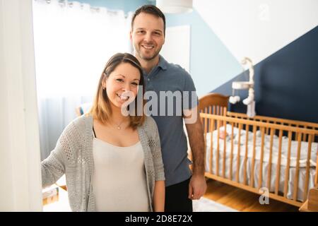 Les parents debout dans la pépinière avec bébé fils Banque D'Images