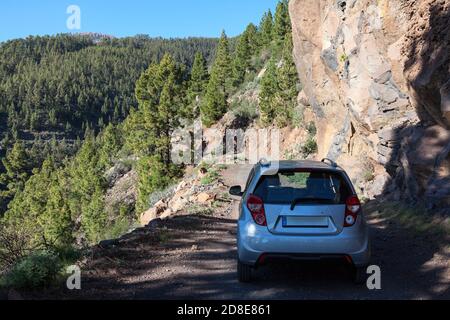 Petite voiture debout à l'ombre des arbres sur la route de campagne de montagne de terre, Voyage en voiture au-dessus de l'île de Ténérife. Canari, Espagne. Banque D'Images