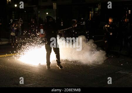 La police fédérale lance des flashbangs et larme des grenades à gaz sur les manifestants. Des manifestants se sont affrontés avec la police fédérale au cours du cinquième mois de manifestations, après que les manifestants se soient approchés d'un bâtiment DE GLACE (Immigration et police des douanes) dans le centre-ville de Portland, Oregon, le 28 octobre 2020. (Photo de John Rudoff/Sipa USA) crédit: SIPA USA/Alay Live News Banque D'Images