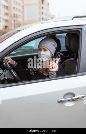 Le conducteur féminin porte un masque facial qui fait des gestes avec l'index pendant la conduite voiture Banque D'Images
