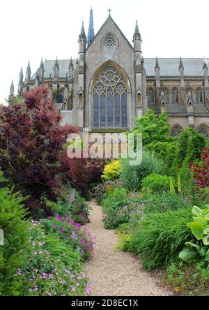 Cathédrale d'Arundel vue au bout d'un sentier dans les jardins du château d'Arundel. Le chemin passe par deux belles bordures herbacées. Banque D'Images