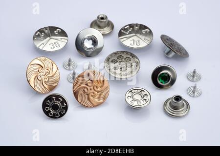 Boutons métalliques pour la confection de vêtements en denim. Boutons pour jeans et vestes avec crampons. Différents types de boutons sur fond blanc. Raccords métalliques pour Banque D'Images