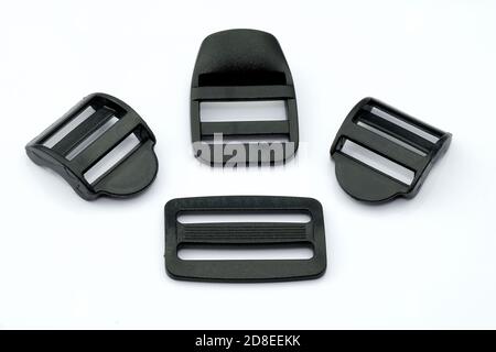 Boucles en plastique noir pour une ceinture sur fond blanc. Sangles en plastique de différentes largeurs pour les sangles d'un sac et d'un sac à dos. Accessoires de couture Banque D'Images