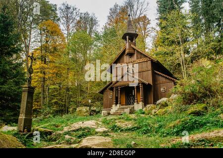 Ancien pèlerinage en bois chapelle rurale de la Vierge Marie, CZ: Stozecka kaple, et croix de fer, debout dans une forêt à l'altitude de 950 m, République Tchèque Banque D'Images