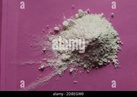 la farine ou le sucre en poudre est entassé dans une pile un arrière-plan rose fuchsia vue de dessus il y a une copie espace pour le texte Banque D'Images