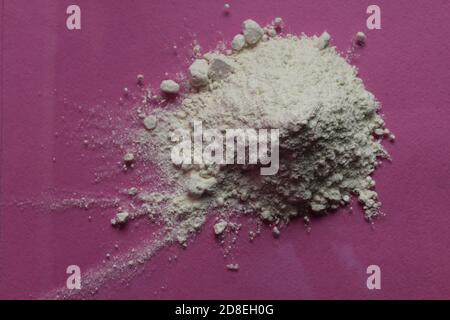 la farine ou le sucre en poudre est entassé dans une pile un arrière-plan rose fuchsia vue de dessus il y a une copie espace pour le texte Banque D'Images