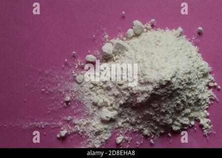 la farine ou le sucre en poudre est entassé dans une pile un arrière-plan rose fuchsia vue de dessus il y a une copie espace pour le texte Banque D'Images
