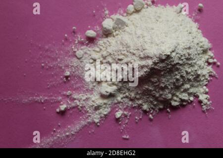 la farine ou le sucre en poudre est entassé dans une pile un arrière-plan rose fuchsia vue de dessus il y a une copie espace pour le texte Banque D'Images