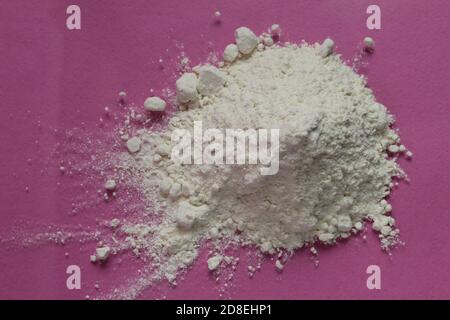 la farine ou le sucre en poudre est entassé dans une pile un arrière-plan rose fuchsia vue de dessus il y a une copie espace pour le texte Banque D'Images