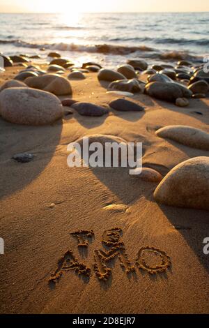 Plage de sable et de rocailleux au coucher du soleil avec 'te amo' (Je t'aime) écrit dans le sable Banque D'Images