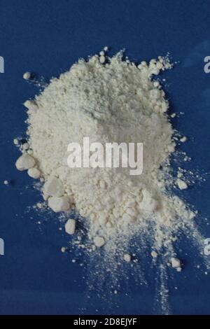 la farine ou le sucre en poudre est entassé dans un tas sur un arrière-plan bleu clair, une vue de dessus est présente copier l'espace pour le texte Banque D'Images