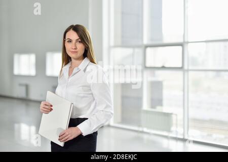 Portrait d'une femme entrepreneur avec des documents entre ses mains sur le fond d'un bureau vide pour de nouvelles affaires Banque D'Images